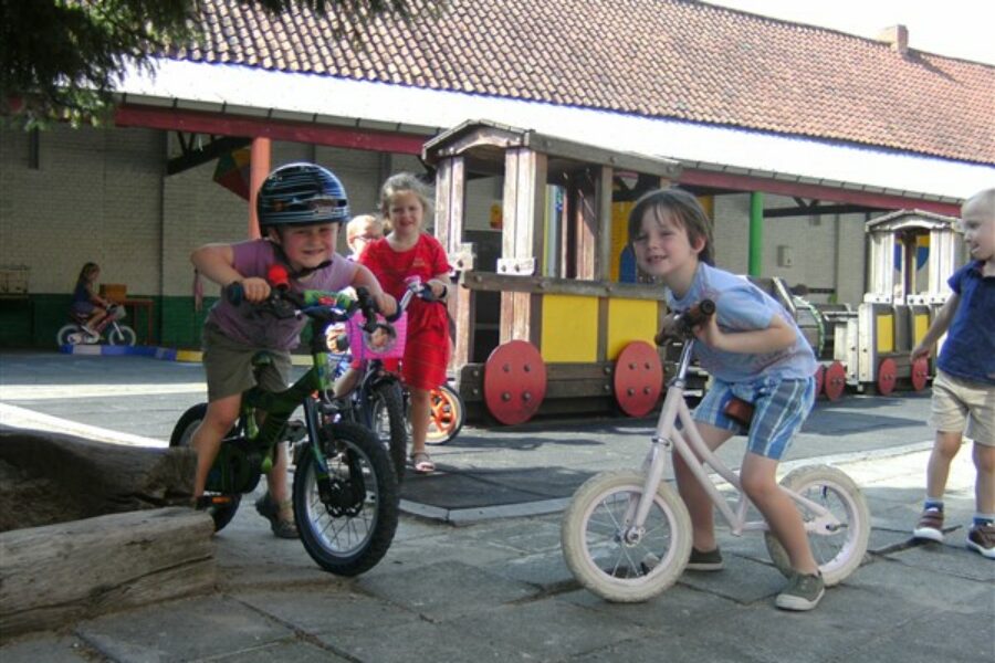 Fietsen met een meegebrachte (loop)fiets, step of met een fietsje van de school.